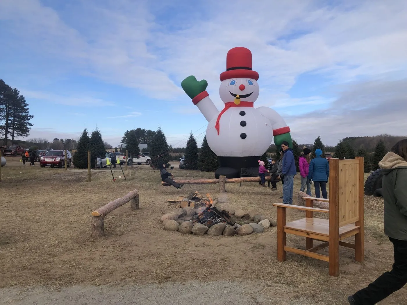 Giant inflatable snowman waves over the Princeton farm fire pit, surrounded by families